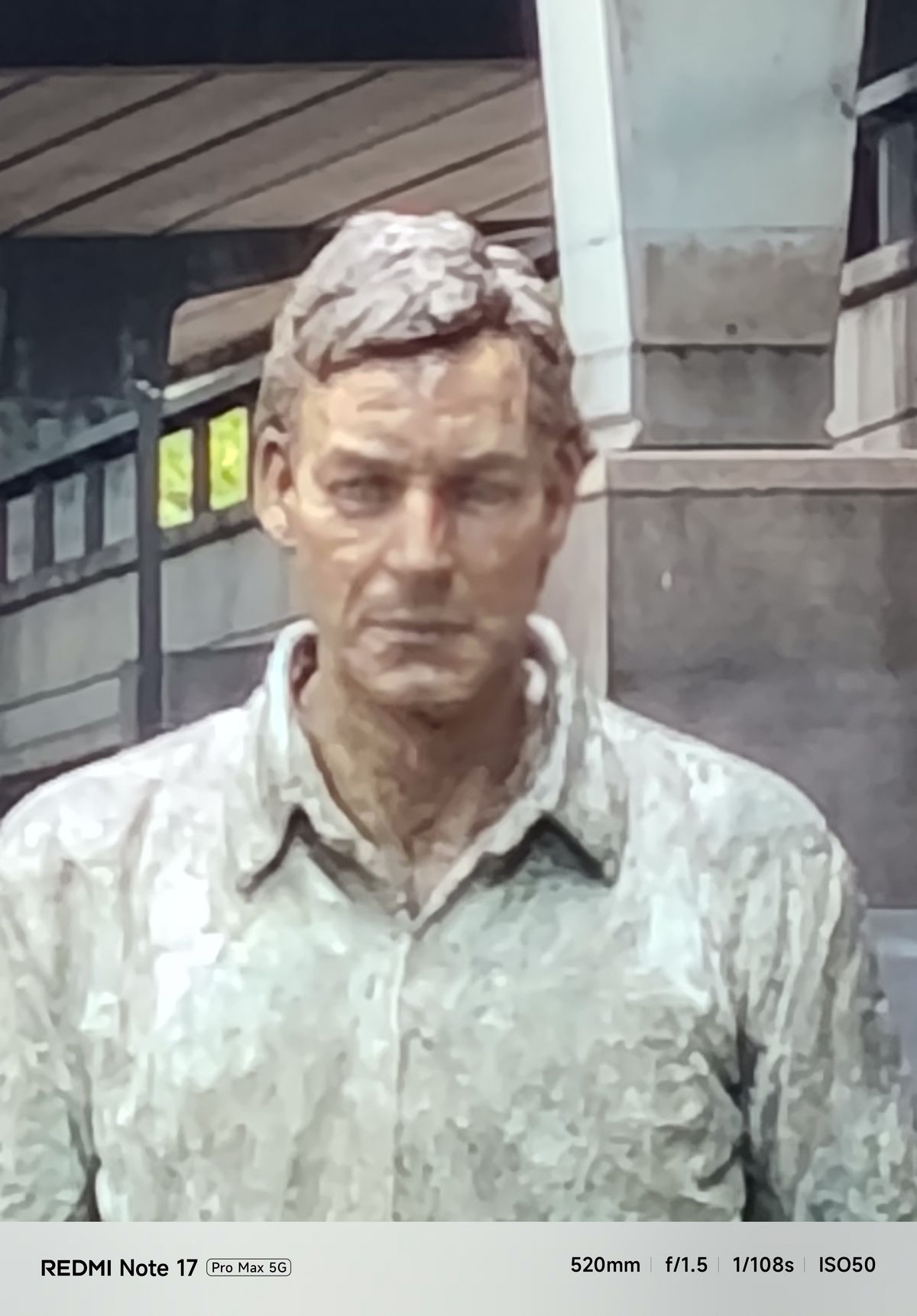 Tightly cropped, soft-looking close-up of the walking man sculpture’s face at 20x digital zoom.